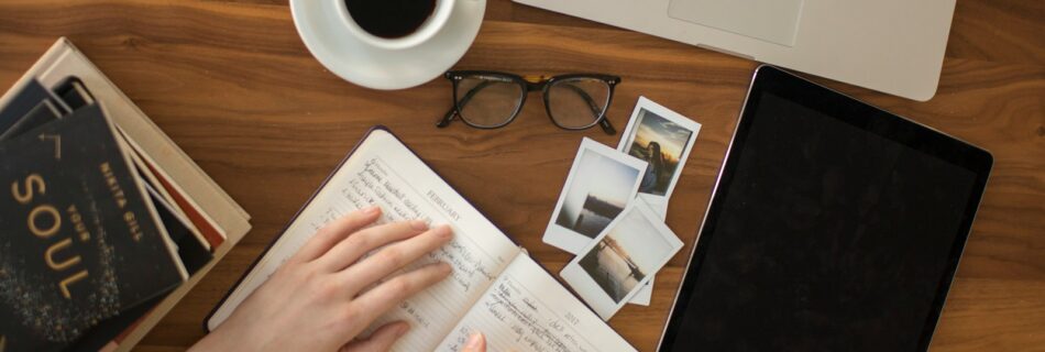 person holding ballpoint pen writing on notebook