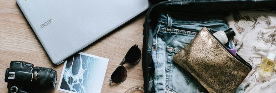 black DSLR camera near sunglasses and bag