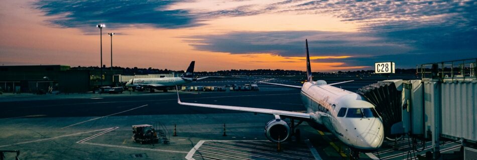 white airplane near trailers during sunset