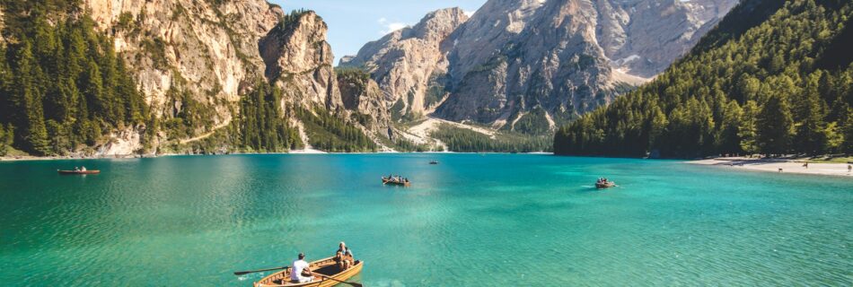 three brown wooden boat on blue lake water taken at daytime